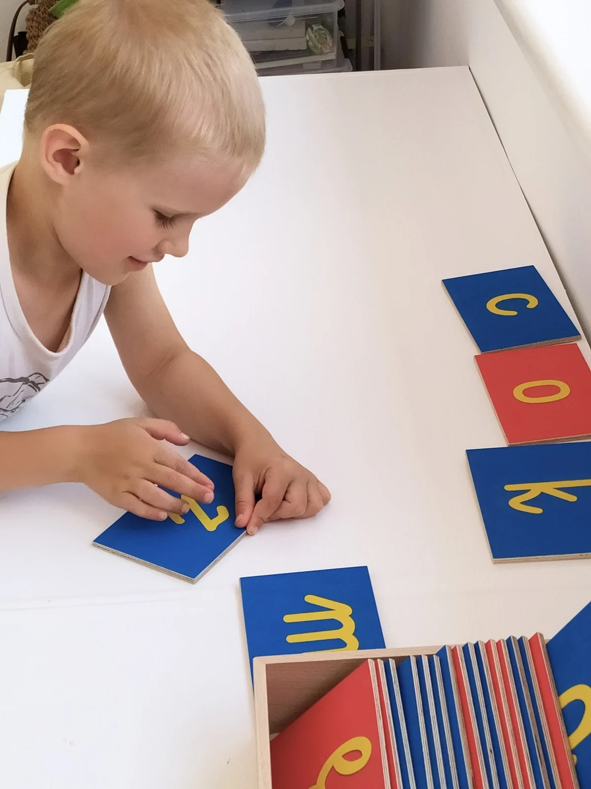 Zdjęcie dziecka patrzącego na tabliczki z literkami
